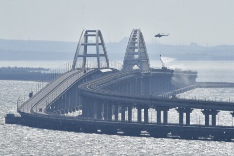 Key Russian bridge to Crimea is struck again as Putin vows response to attack that killed 2