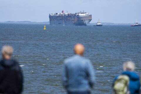 A car-carrying ship that burned for a week on the North Sea is towed to a Dutch port for salvaging