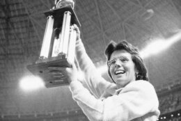 FILE - In this Sept. 20, 1973, file photo, Billie Jean King holds the winner's trophy high in the air after she defeated Bobby Riggs in the $100,000 winner-take-all tennis match at the Astrodome in Houston, Texas. King set Riggs down 6-4, 6-3, 6-3. (AP Photo/File)