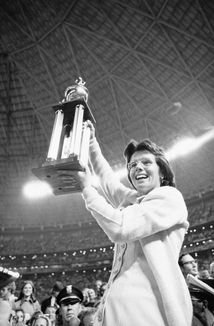 FILE - In this Sept. 20, 1973, file photo, Billie Jean King holds the winner's trophy high in the air after she defeated Bobby Riggs in the $100,000 winner-take-all tennis match at the Astrodome in Houston, Texas. King set Riggs down 6-4, 6-3, 6-3. (AP Photo/File)
