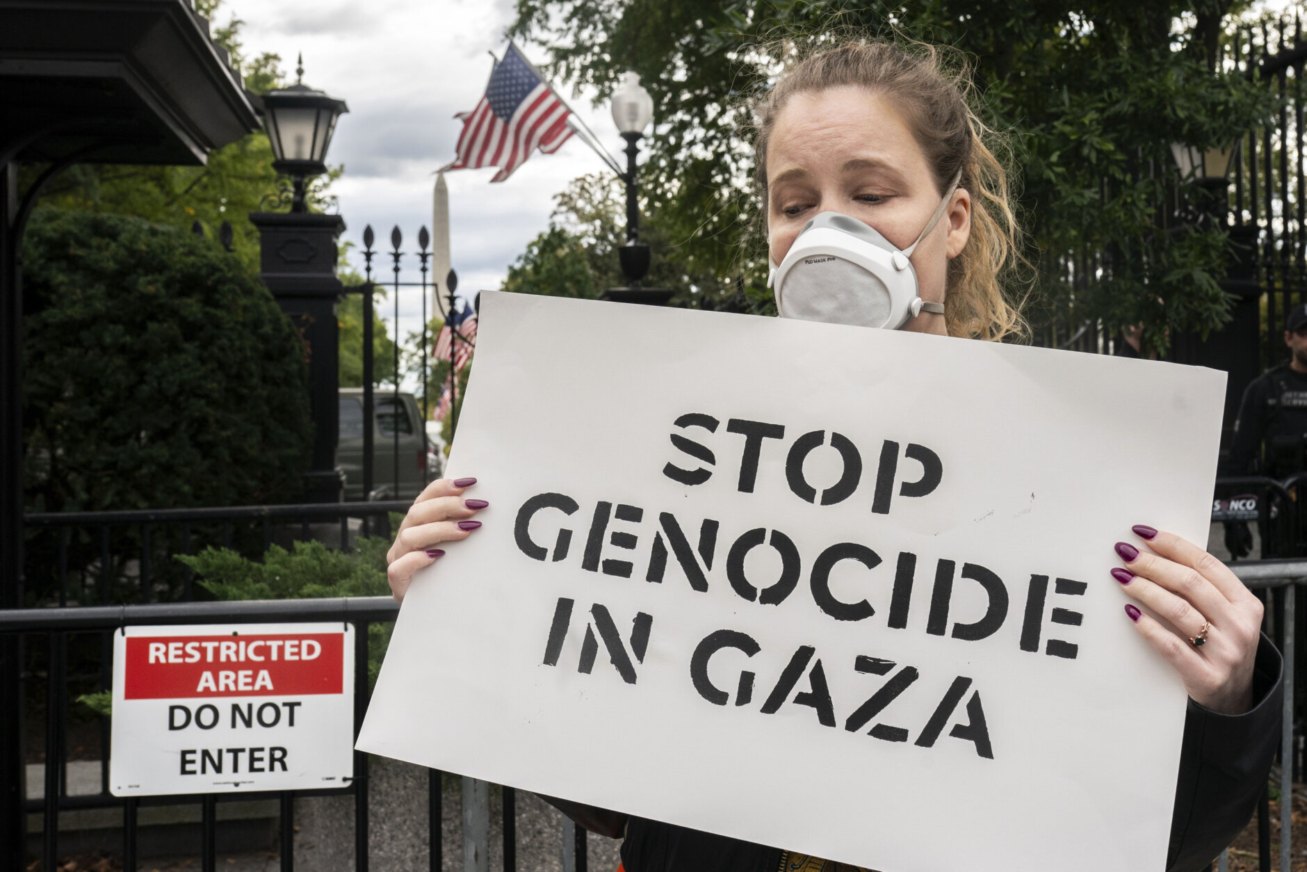 With the Washington Monument in the background, a protester blocks an entrance to the White House during a demonstration calling for a ceasefire in Gaza in Washington, Monday, Oct. 16, 2023. (AP Photo/Nathan Howard)