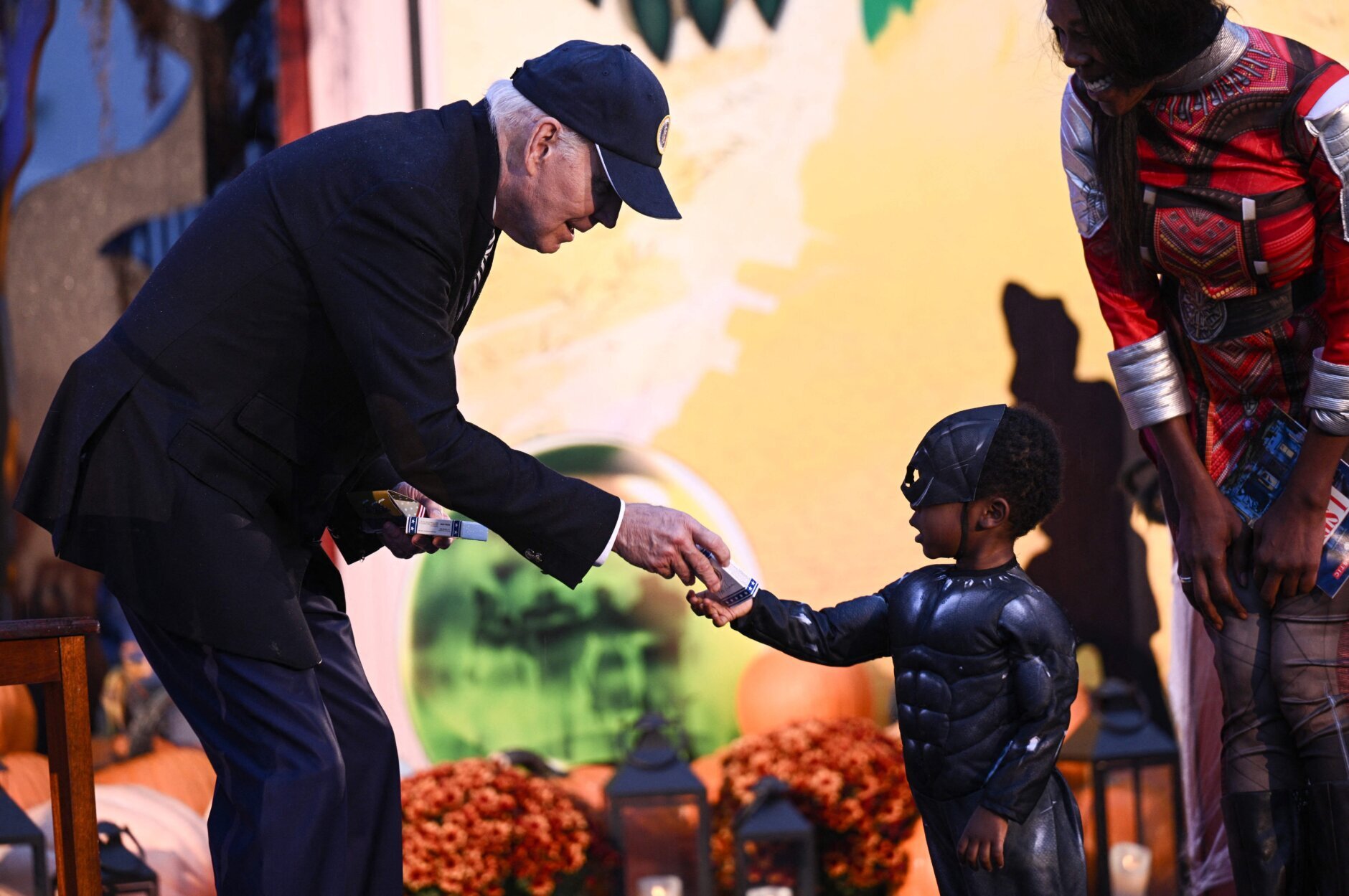 Joe Biden interacts with a boy dressed as a superhero