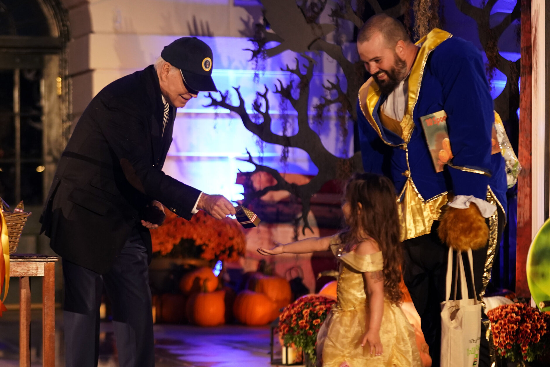 A family dressed as characters from Beauty and the Beast are greeted by Joe Biden