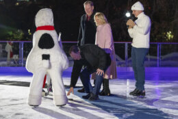 Will Shafroth, President and CEO of the National Park Foundation, left, first lady Jill Biden, and 1988 Olympic figure skater Brian Boitano, watch as Gary Bettman, Commissioner of the National Hockey League, drops a puck for Snoopy during the unveiling of the White House Holiday Ice Rink, located at the south panel of the South Lawn of the White House complex, Wednesday, Nov. 29, 2023, in Washington. (AP Photo/Jacquelyn Martin)