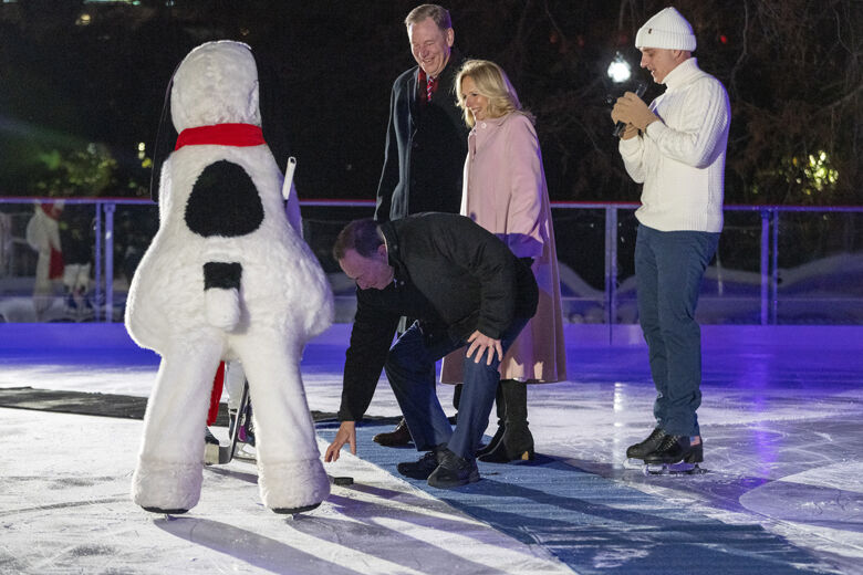 Will Shafroth, President and CEO of the National Park Foundation, left, first lady Jill Biden, and 1988 Olympic figure skater Brian Boitano, watch as Gary Bettman, Commissioner of the National Hockey League, drops a puck for Snoopy during the unveiling of the White House Holiday Ice Rink, located at the south panel of the South Lawn of the White House complex, Wednesday, Nov. 29, 2023, in Washington. (AP Photo/Jacquelyn Martin)