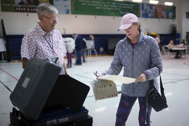 Woman submits her ballot at Newton-Lee Elementary School in Ashburn, Virginia