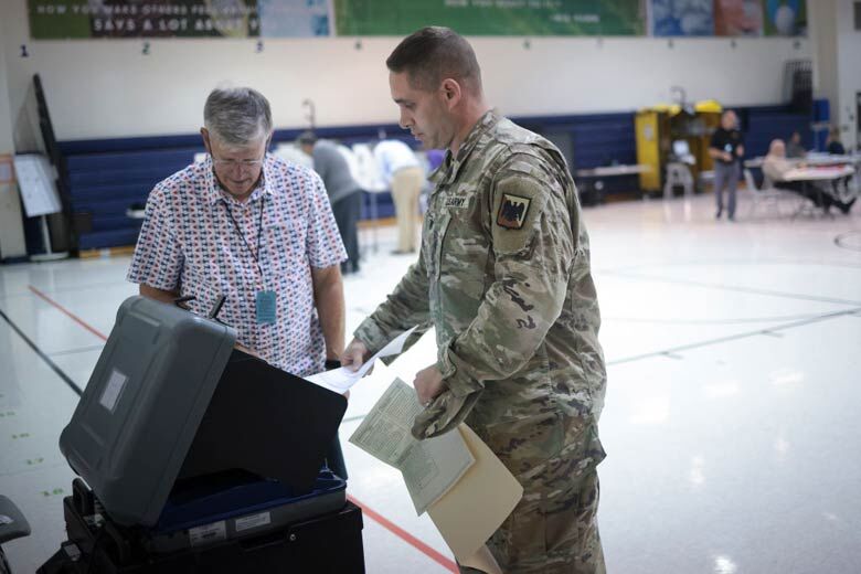 U.S. service member submits his ballot at Newton-Lee Elementary School in Ashburn, Virginia