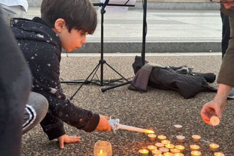 A young child lights candles