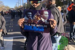 Man holding poster showing Petey Green, Barack Obama and Marion Barry