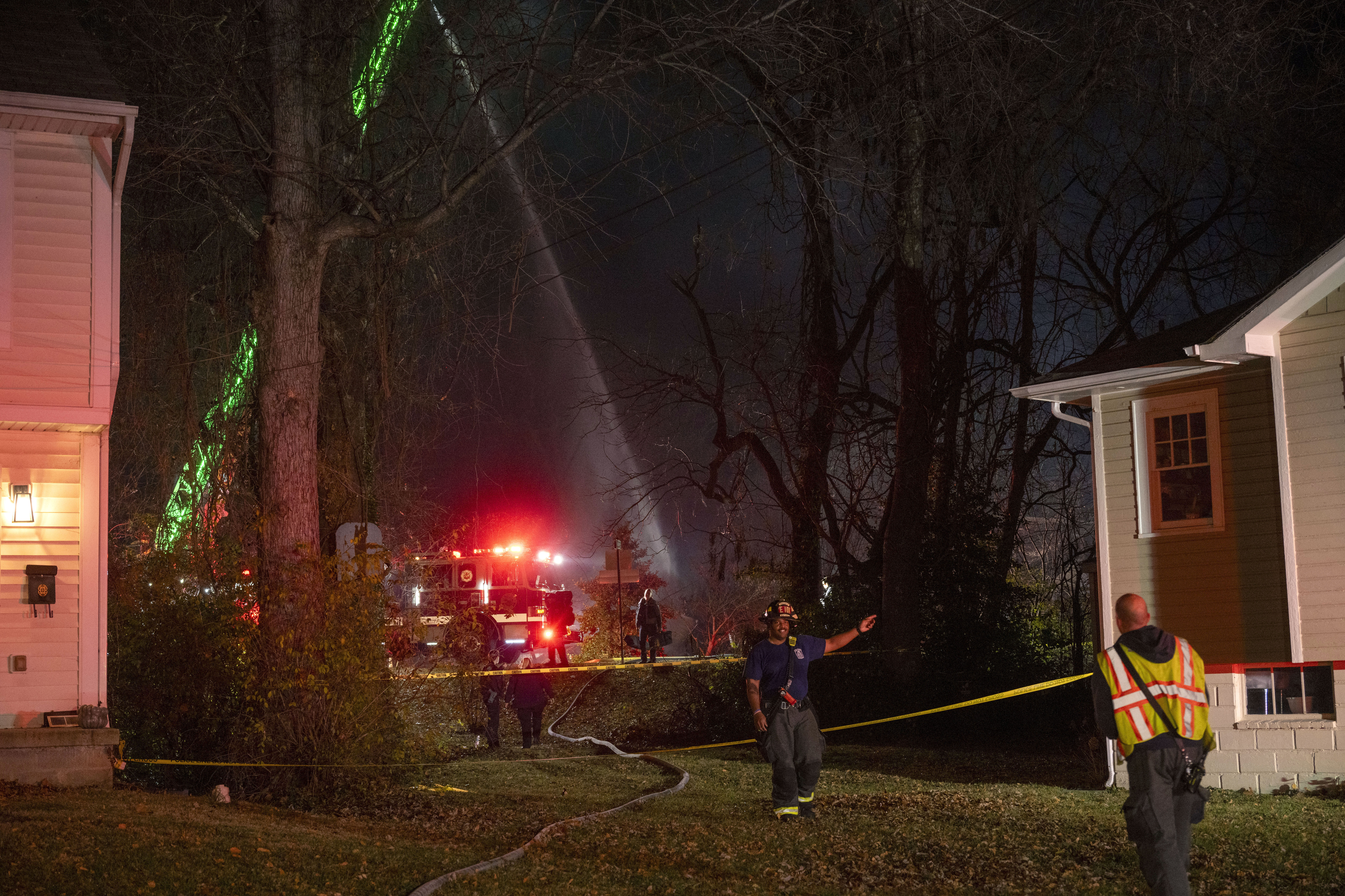 Fire truck sprays water down the remains of a house.