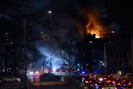 Flames shoot from a two alarm fire, at right, that started in a former fire station, Old Engine Company No. 12, now a landmark along North Capitol Street, in the Bloomingdale neighborhood of Washington, Friday, Dec. 15, 2023. (AP Photo/Andrew Harnik)