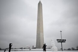 A family poses next to a snowman at the Washington Monument on the National Mall in Washington, DC, on January 16, 2024. The Washington DC metro region received between 2 and 4 inches (5-10cm) of snow on January 15, 2024. (Photo by ANDREW CABALLERO-REYNOLDS / AFP) (Photo by ANDREW CABALLERO-REYNOLDS/AFP via Getty Images)