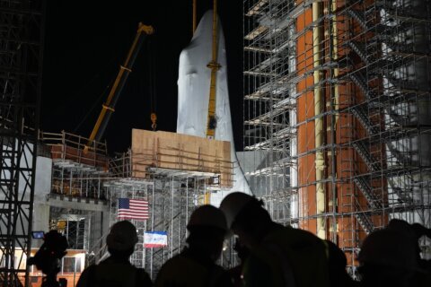 Space shuttle Endeavour hoisted for display in launch configuration at Los Angeles science museum
