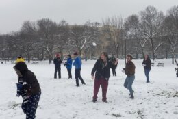 a group throws snowballs at each other on the National Mall