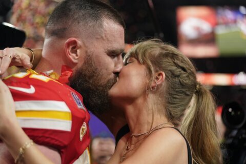 Taylor Swift kisses Travis Kelce on the field after his Chiefs beat the 49ers in the Super Bowl