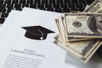 Tuition fee or student loan with calculator. Education price , savings fund college, and expenses concept. Money and papers on table. Calculating budget and planning finance.