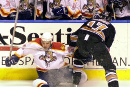 Florida Panthers' Ivan Novoseltsev, left, of Russia, is checked to the ice by Washington Capitals' Chris Simon (17) during the first period Wednesday, Dec. 19, 2001, in Sunrise, Fla. (AP Photo/Tony Gutierrez)