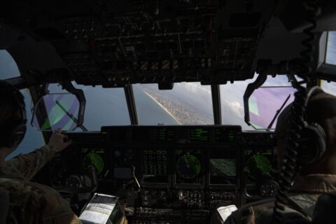 AP reporters aboard a US military plane watch small batches of aid airdropped on a destroyed Gaza