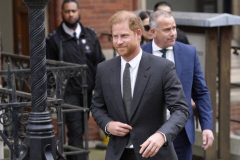 Prince Harry says tabloids intercepted phone calls of mother, the late Princess Diana, and father