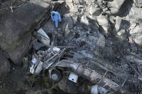 Burned bodies of Easter pilgrims still lie inside a bus that crashed off a bridge in South Africa
