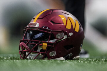 A Washington Commanders helmet sits on the field before the first half of an NFL football game against the Atlanta Falcons, Sunday, Oct. 15, 2023, in Atlanta. The Washington Commanders won 24-16. (AP Photo/Danny Karnik)