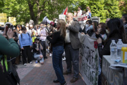 George Washington University faculty professors Will Youmans, center right, and Rochelle Davis, center left, lead a group of professors during a pro-Palestinian protest over the Israel-Hamas war on Friday, April 26, 2024, in Washington. (AP Photo/Jose Luis Magana)