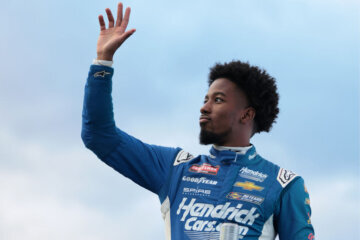MARTINSVILLE, VIRGINIA - APRIL 05: Rajah Caruth, driver of the #71 HendrickCars.com Chevrolet, waves to fans as he walks onstage during driver intros prior to during the NASCAR Craftsman Long John Silver's 200 at Martinsville Speedway on April 05, 2024 in Martinsville, Virginia. (Photo by James Gilbert/Getty Images)