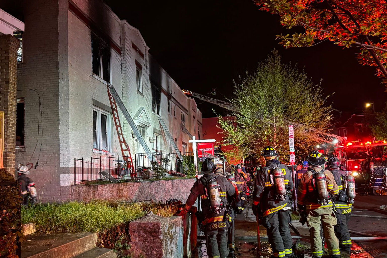 Firefighters outside burned apartment building