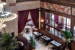 The interior includes classical motifs, a marble entrance, and mahogany wood and glass partitions, and a 20 foot curved bar imported from Paris. (Courtesy The Group Hospitality)