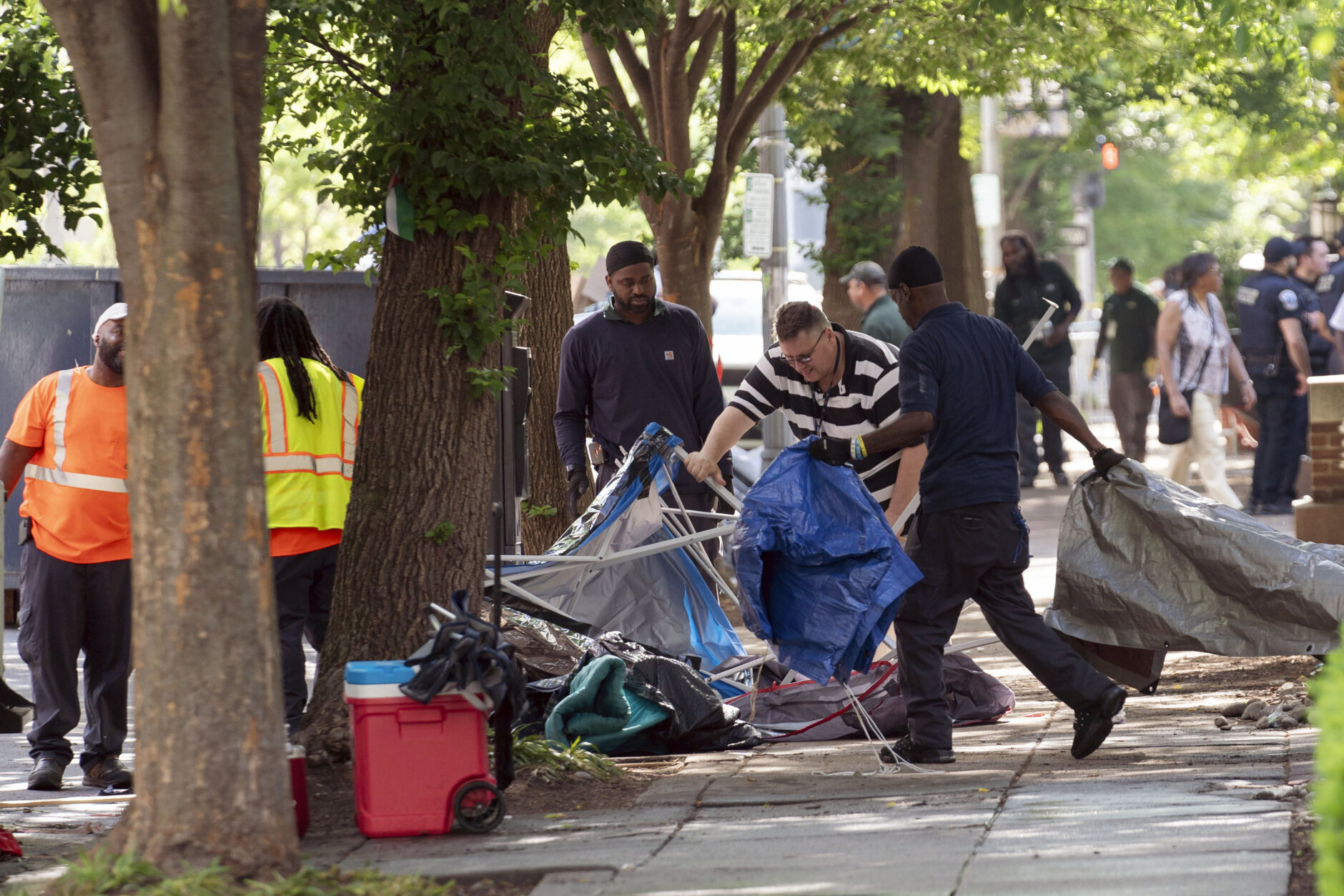 Workers carry student tents to a dump truck after police cleared a pro-Palestinian tent encampment at George Washington University early Wednesday and arrested demonstrators, Wednesday, May 8, 2024, in Washington. (AP Photo/Jose Luis Magana)