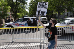 A demonstrator walks near where earlier police had cleared a pro-Palestinian tent encampment at George Washington University early Wednesday and arrested demonstrators, Wednesday, May 8, 2024, in Washington. (AP Photo/Jose Luis Magana)