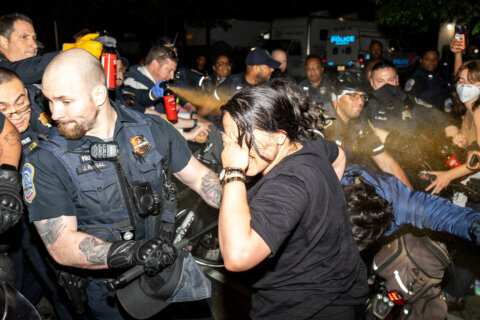 Officers of the Metropolitan Police Department pepper spray demonstrators at George Washington University in Washington, early Wednesday, May 8, 2024. Police cleared a pro-Palestinian tent encampment at the university and arrested demonstrators early Wednesday, hours after dozens marched to the home of the school’s president.