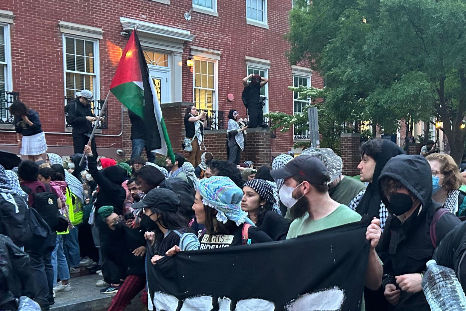 Protesters have climbed a home that's traditionally where the university president lives.