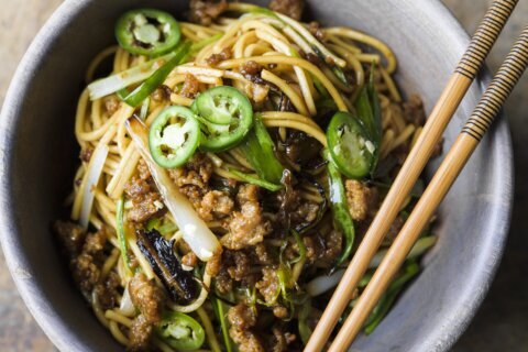 Thinly sliced fried scallions add bold flavor to savory pork noodles