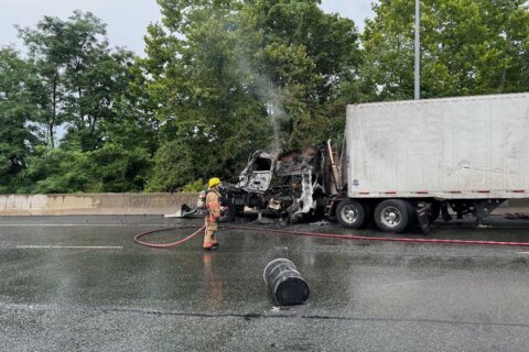 Tractor-trailer catches fire, more than a dozen barrels of metal spill onto I-495