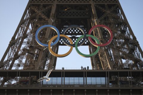 The Olympic rings are mounted on the Eiffel Tower to mark 50 days until the Paris Games