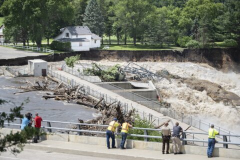 Swollen river claims house next to Minnesota dam as flooding and extreme weather grips the Midwest
