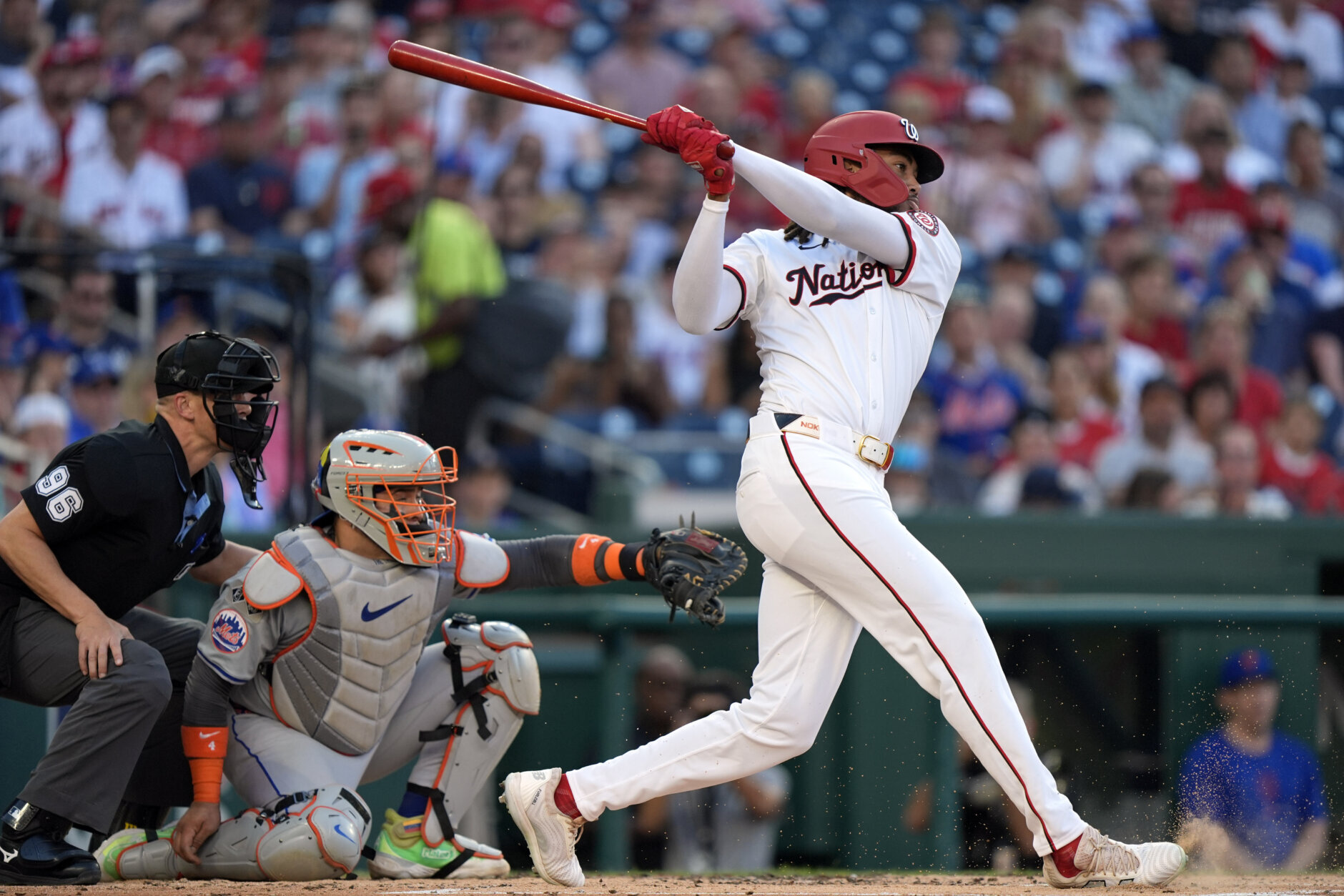 Washington Nationals' James Wood, right, connects with a pitch during his first major league at-bat during the second inning of a baseball game against the New York Mets at Nationals Park, Monday, July 1, 2024, in Washington. (AP Photo/Mark Schiefelbein)