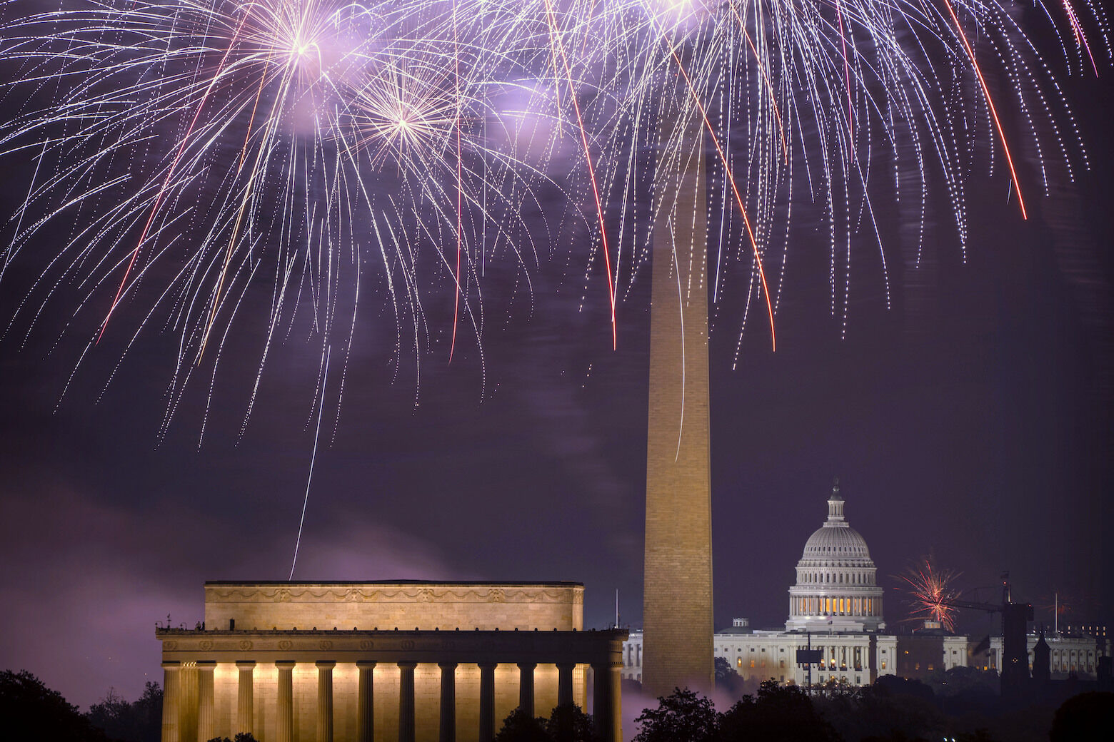 Fireworks burst above the National Mall, and from left, the Lincoln Memorial, Washington Monument and the U.S. Capitol building during Independence Day celebrations on Thursday, July 4, 2024 in Washington. (AP Photo/Mark Schiefelbein)