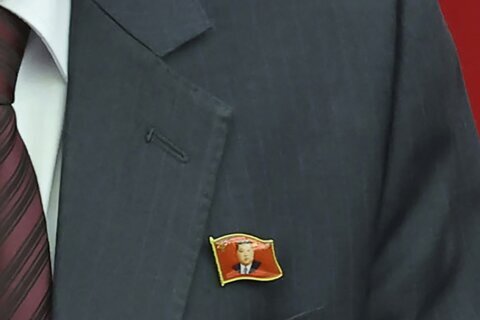 North Koreans are seen wearing Kim Jong Un pins for the first time as his personality cult grows
