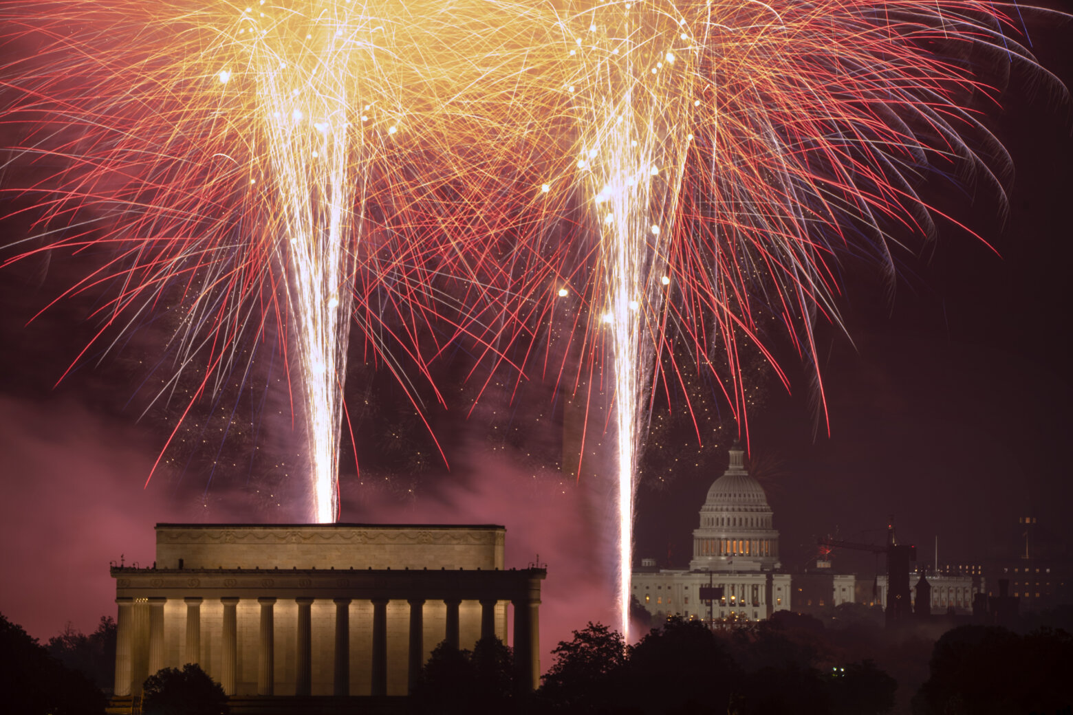 Fireworks burst above the National Mall,