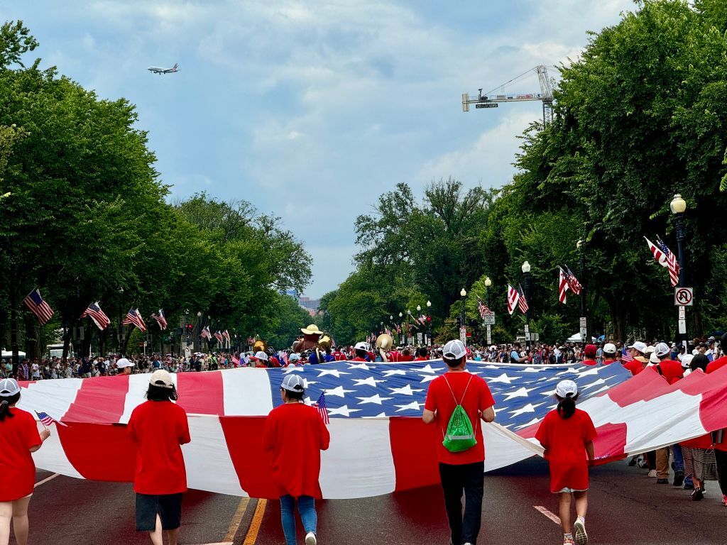 Parade participants in D.C. carry a massive American Flag