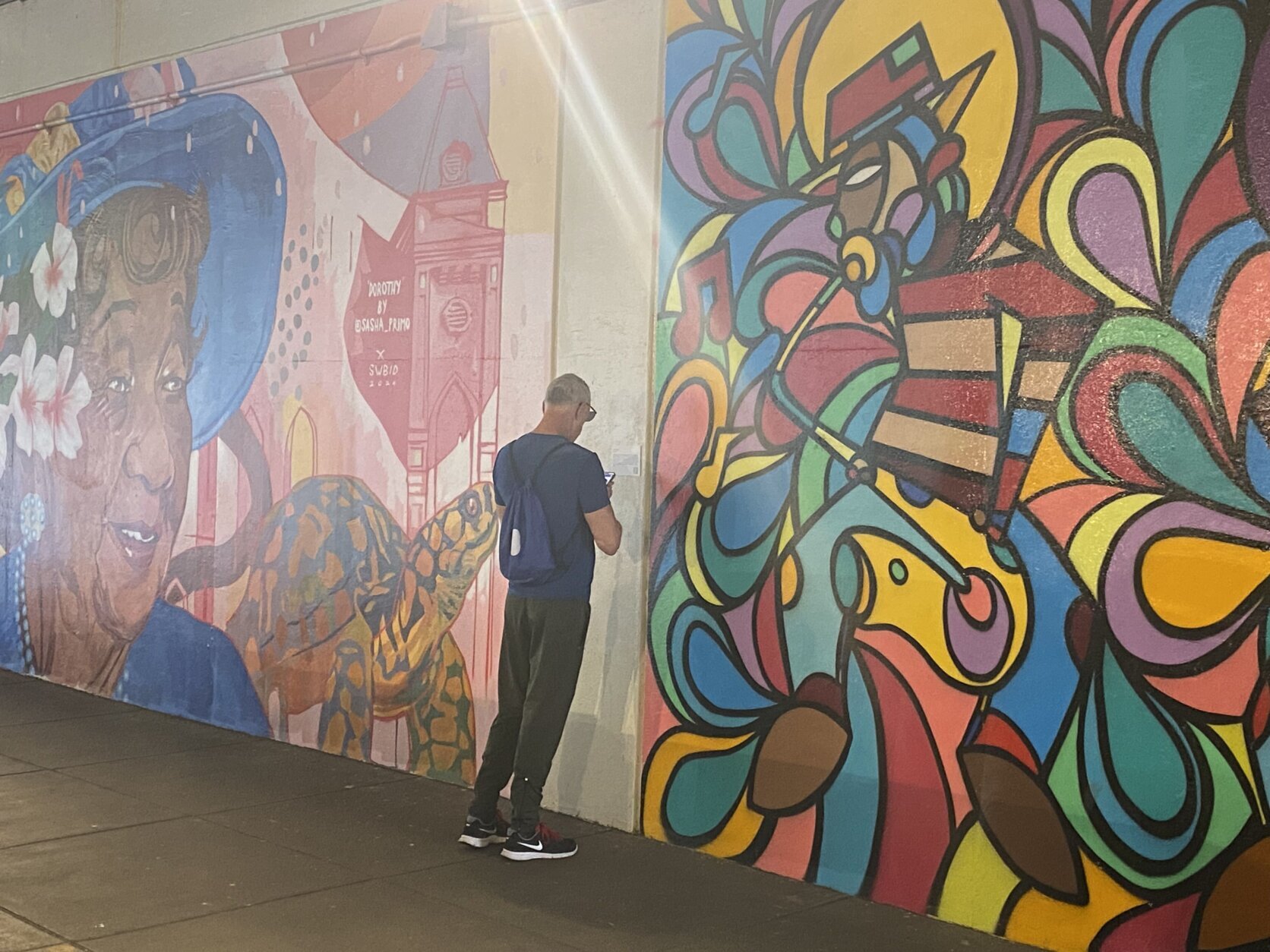A man standing in front of a mural