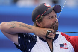 Brady Ellison, of the United States, competes along with Casey Kaufhold during the Archery mixed team quarterfinal against , Japan's Satsuki Noda and Japan's Junya Nakanishi at the 2024 Summer Olympics, Friday, Aug. 2, 2024, in Paris, France. (AP Photo/Brynn Anderson)