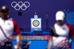 Casey Kaufhold, of the United States, right, competes along with Brady Ellison during the Archery mixed team semifinal against Germany's Michelle Kroppen and Florian Unruh at the 2024 Summer Olympics, Friday, Aug. 2, 2024, in Paris, France. (AP Photo/Brynn Anderson)
