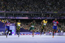 Noah Lyles, of the United States, left, wins the men's 100-meter final ahead of Kishane Thompson, of Jamaica, second from right, at the 2024 Summer Olympics, Sunday, Aug. 4, 2024, in Saint-Denis, France. (AP Photo/Petr David Josek)