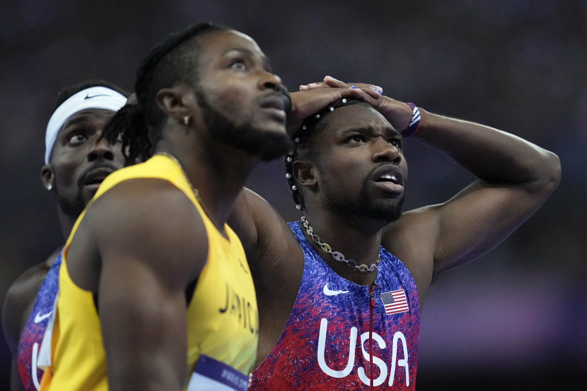 Kishane Thompson, of Jamaica, Noah Lyles, of the United States, right, and Fred Kerley, of the United States, left, wait for the official results after finishing the men's 100 meters final at the 2024 Summer Olympics, Sunday, Aug. 4, 2024, in Saint-Denis, France. Lyles won, Thompson was second and Kerley third. (AP Photo/Ashley Landis)