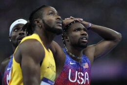 Kishane Thompson, of Jamaica, Noah Lyles, of the United States, right, and Fred Kerley, of the United States, left, wait for the official results after finishing the men's 100 meters final at the 2024 Summer Olympics, Sunday, Aug. 4, 2024, in Saint-Denis, France. Lyles won, Thompson was second and Kerley third. (AP Photo/Ashley Landis)