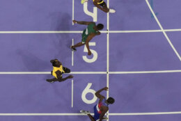 Noah Lyles, of the United States, in lane seven, wins the men's 100-meter final at the 2024 Summer Olympics, Sunday, Aug. 4, 2024, in Saint-Denis, France. (AP Photo/David J. Phillip)