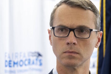 close up shot of stern looking man wearing glasses